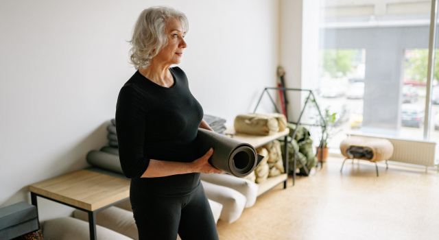 Older Woman Holding a Yoga Mat